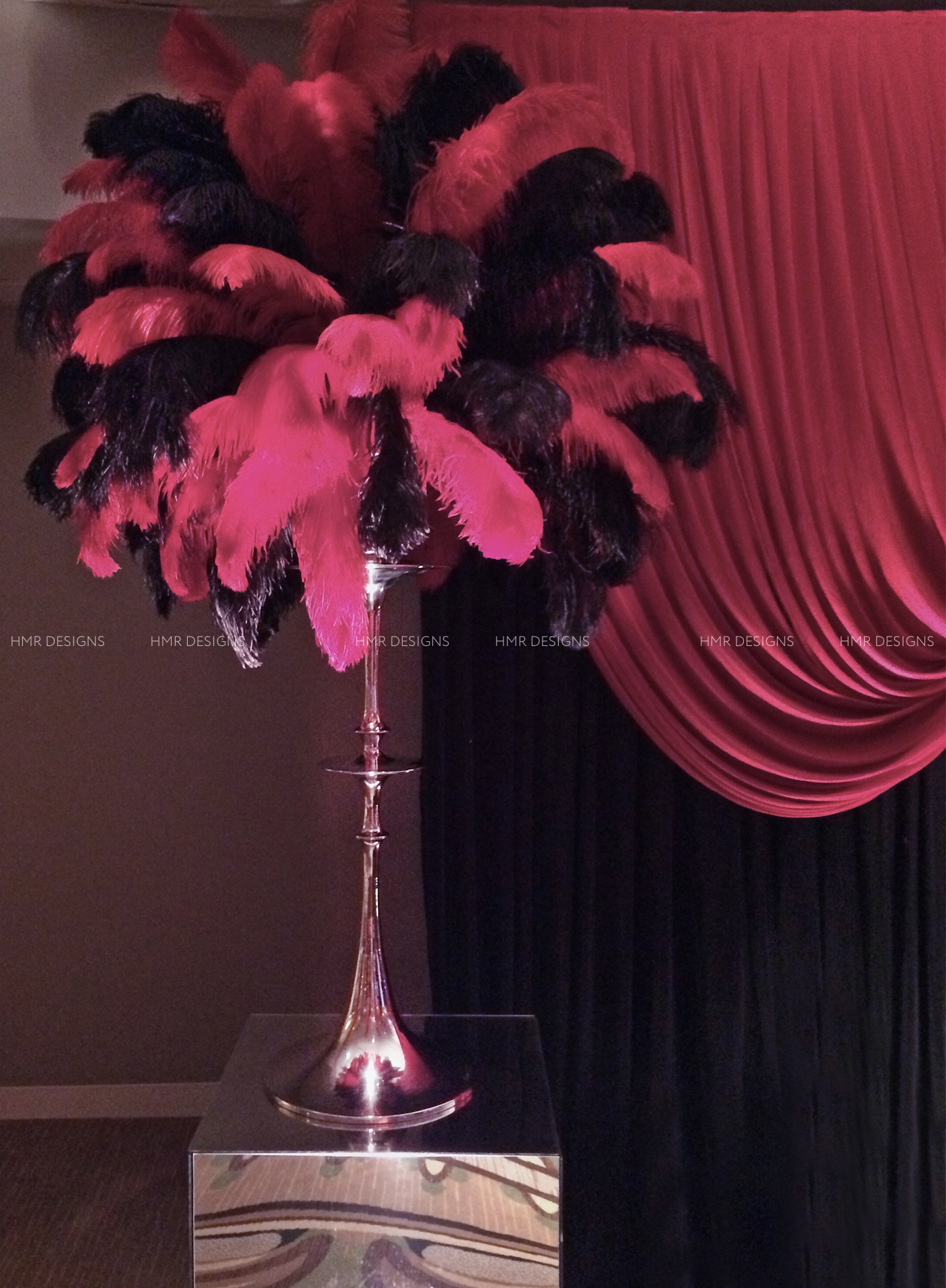 Red and black feathers burst from sleek silver bases for corporate centerpieces designed by HMR Designs